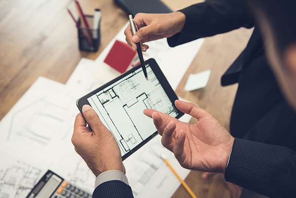 General Properties team working on a development project Real estate agent with client or architect team checking a housing model and its blueprints digitally using a tablet
